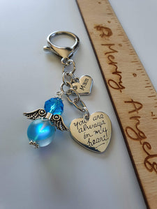 This is a picture of a silver angel keyring with beautiful silver charms. The angel is blue