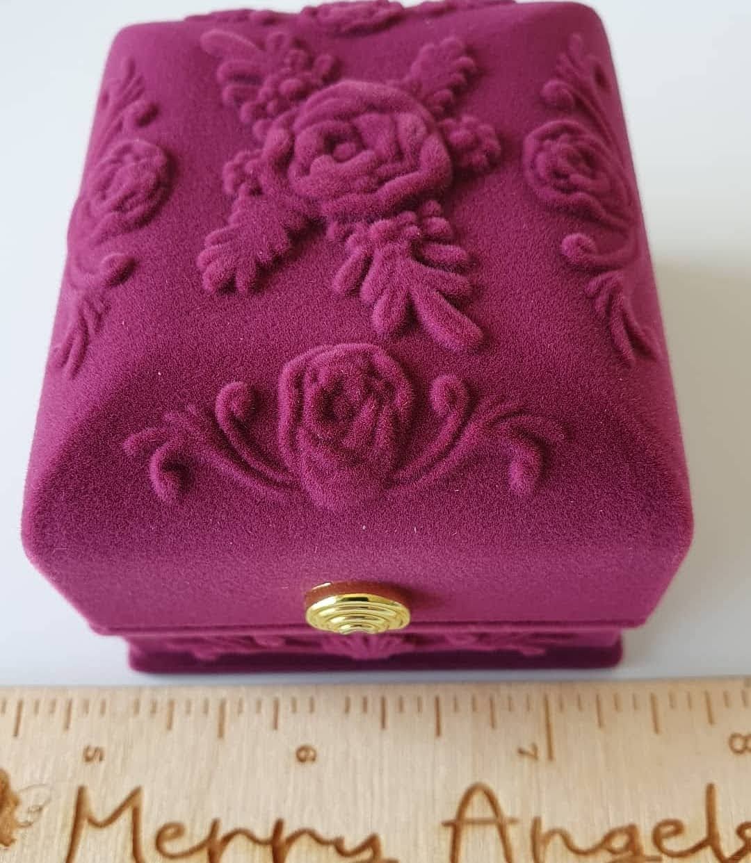 This picture shows a beautiful pink suede box with rose details on the lid