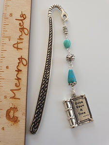 This is a picture of a silver bookmark with turquoise beads and a silver book charm with the engraving 'once upon a time'.