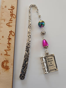 This is a picture of a silver bookmark with pink bead and silver book charm with the engraving 'once upon a time'.