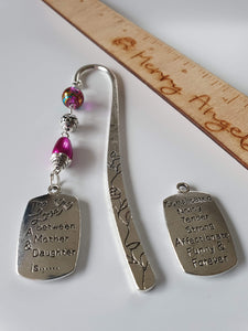 This is a picture of a silver bookmark with pink beads and a silver charm attached with the engraving on the front that reads 'The love between a mother and daughter is......' and an engraving on the back that reads 'Complicated, noisy, tender, strong, affectionate, funny & forever'. 