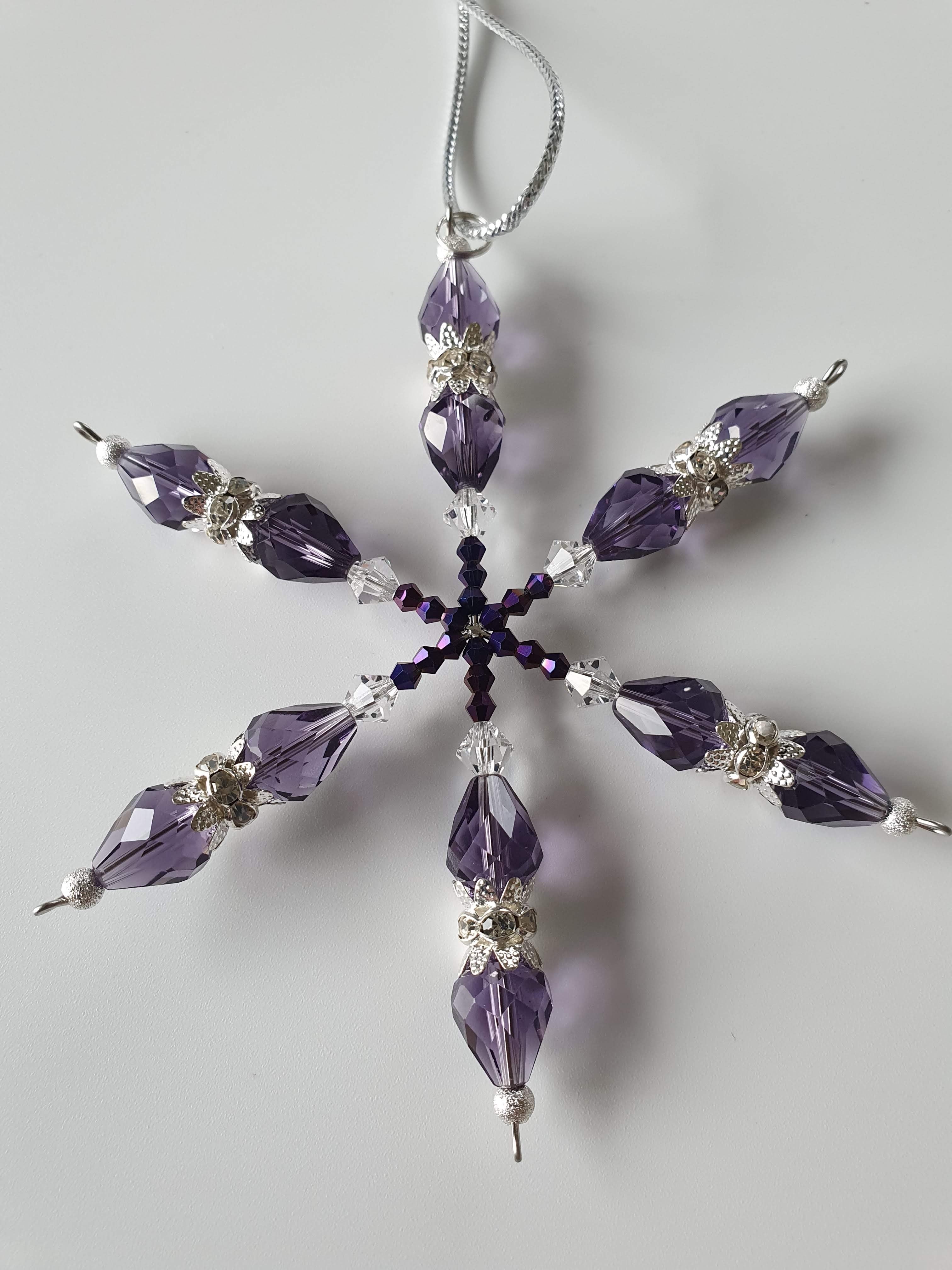 A silver snowflake with purple beads. 
