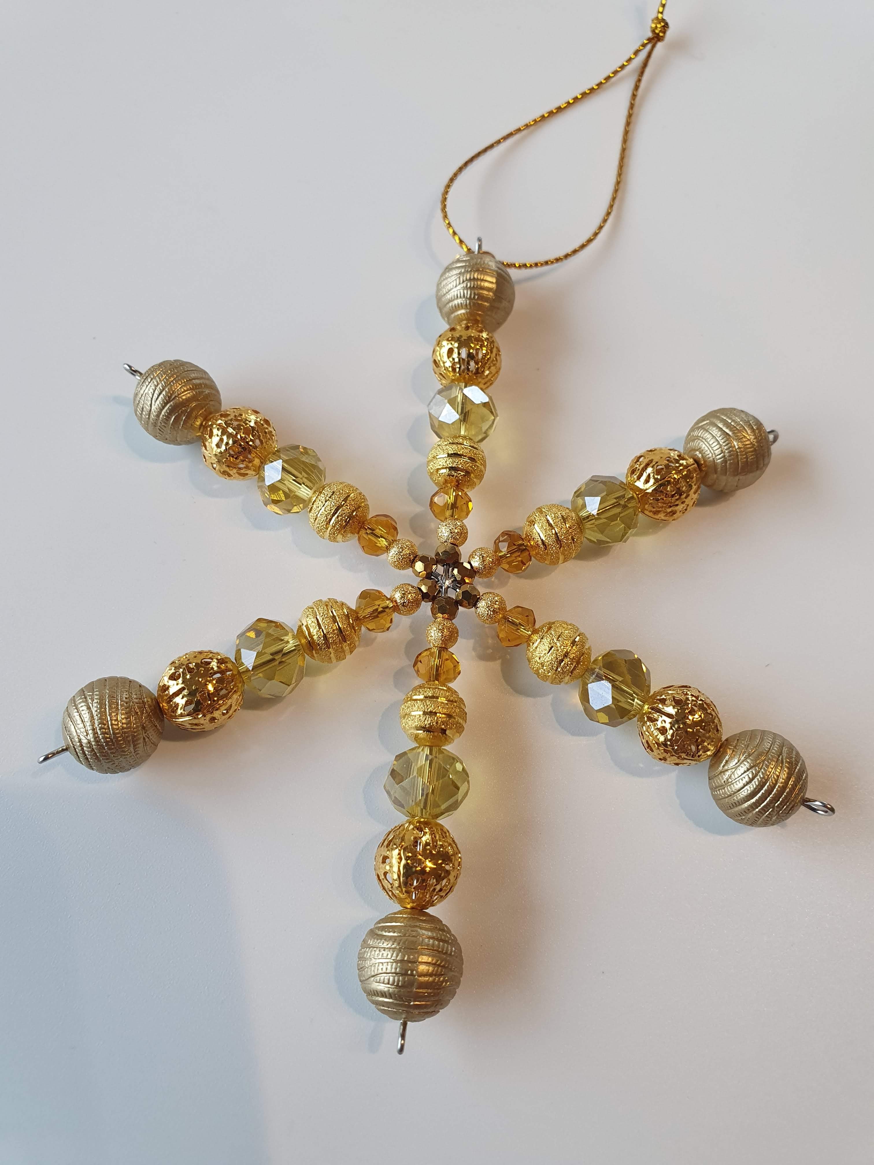A silver snowflake with gold beads.