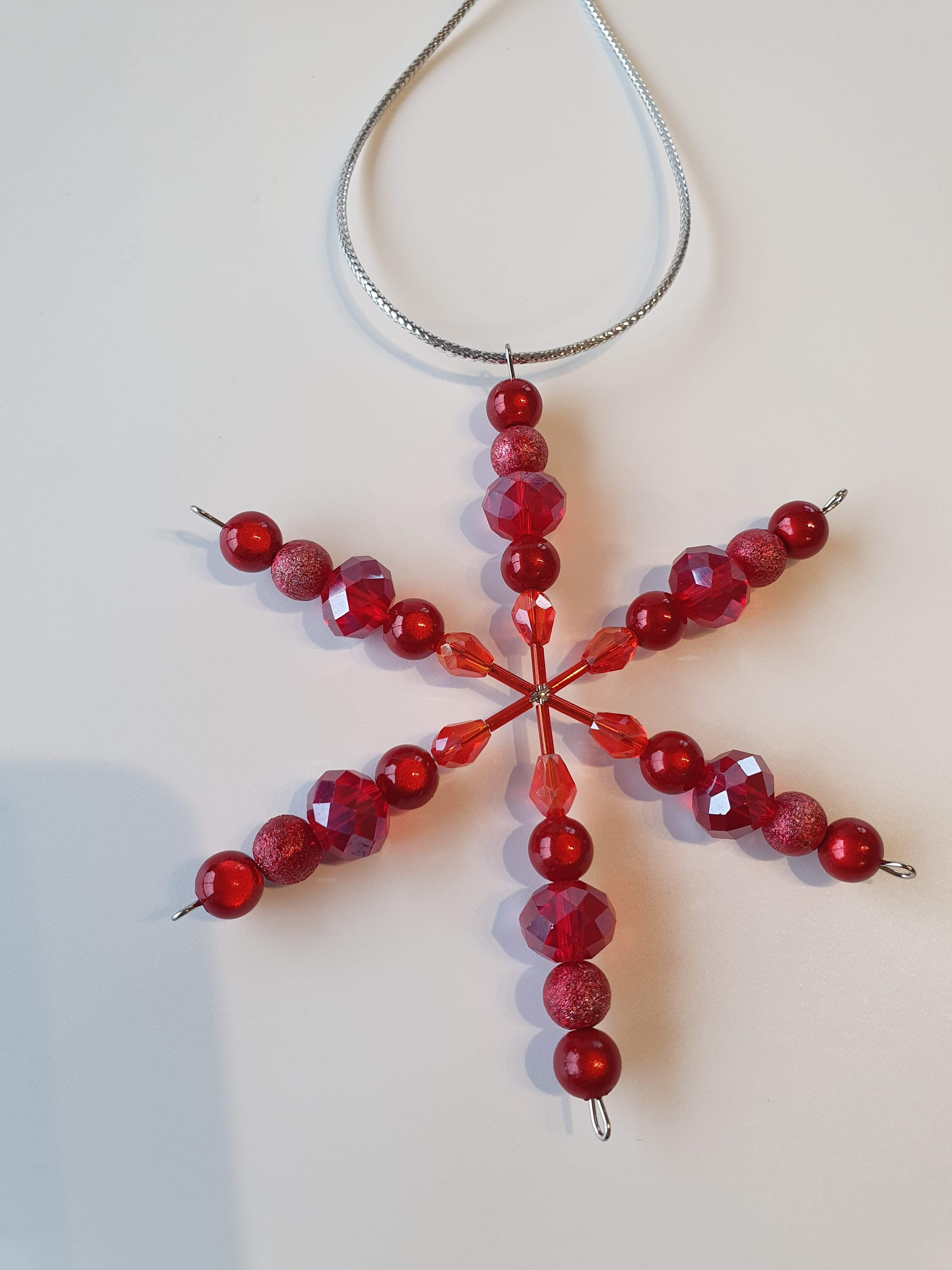 A silver snowflake with red beads.