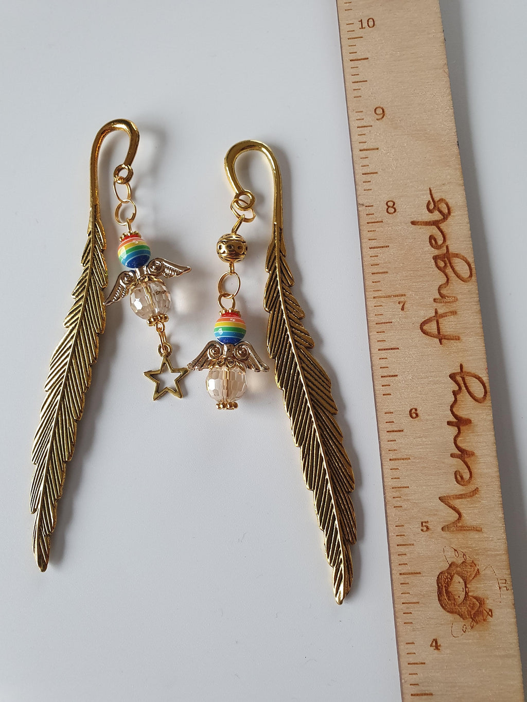 This is a picture of two angel feather bookmarks. Each angel has beautiful rainbow colours on their heads