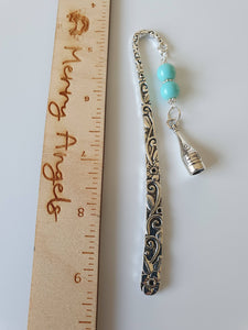 Silver bookmark with turquoise beads and a silver wine bottle charm. 