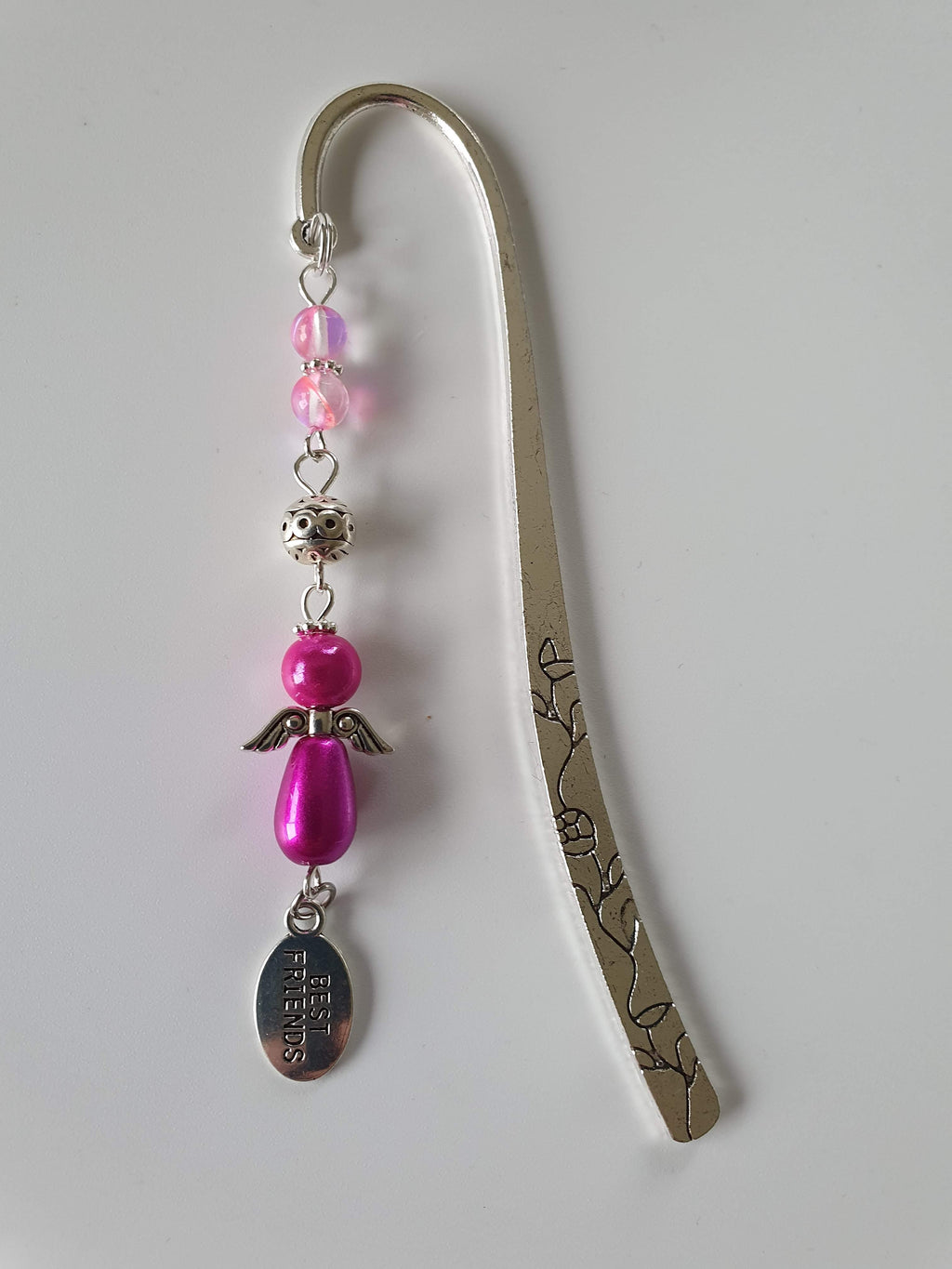 This is a picture of a silver bookmark with a pink angel and a 'best friends' charm