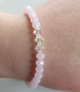 This is a picture of a baby pink and clear bracelet on a wrist