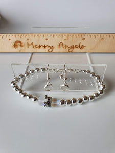This is a picture of a silver bead bracelet with a silver crown and two clear beads. 