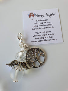 This is a picture of a clear angel hug with a silver tree of life charm attached