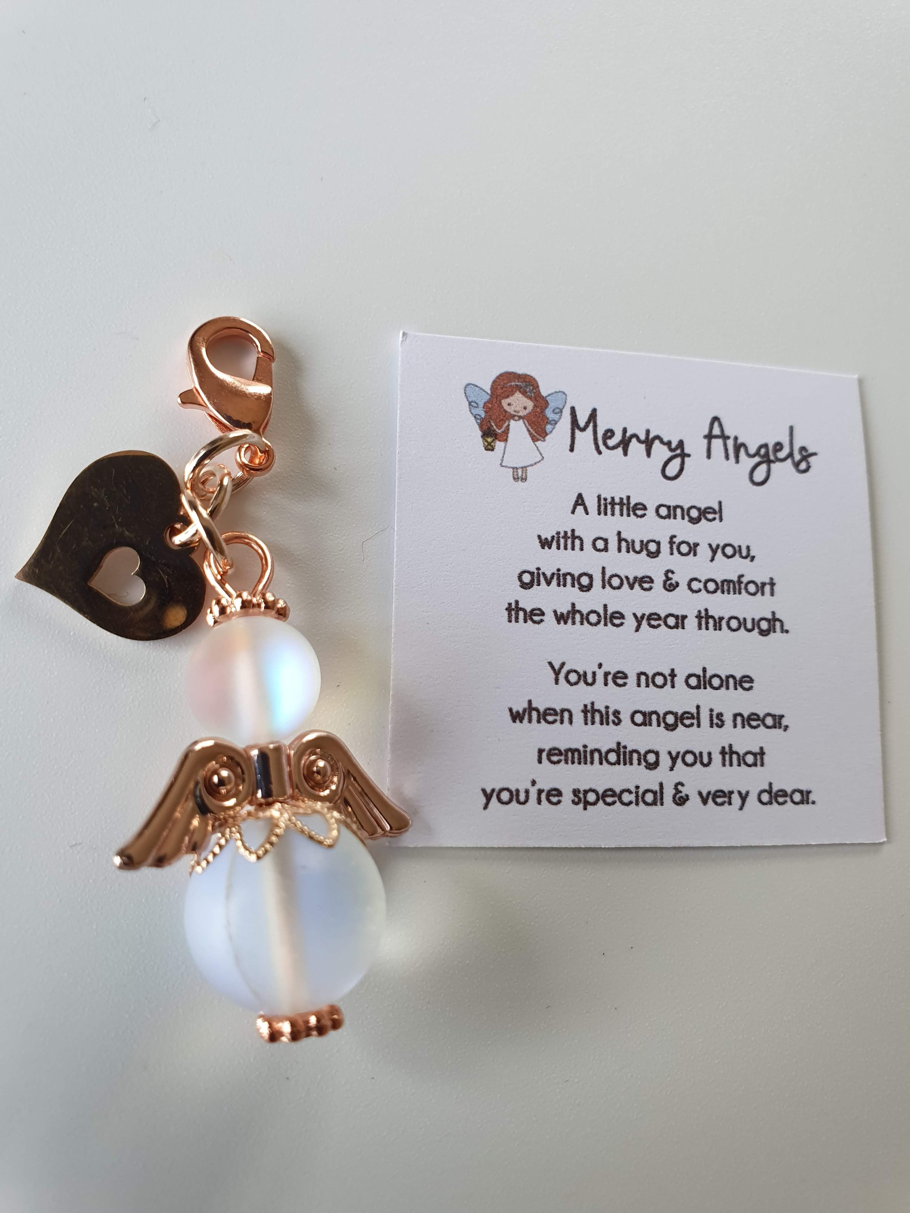 This is a picture of a clear angel hug with rose gold wings and feet and a rose golld heart charm attached 