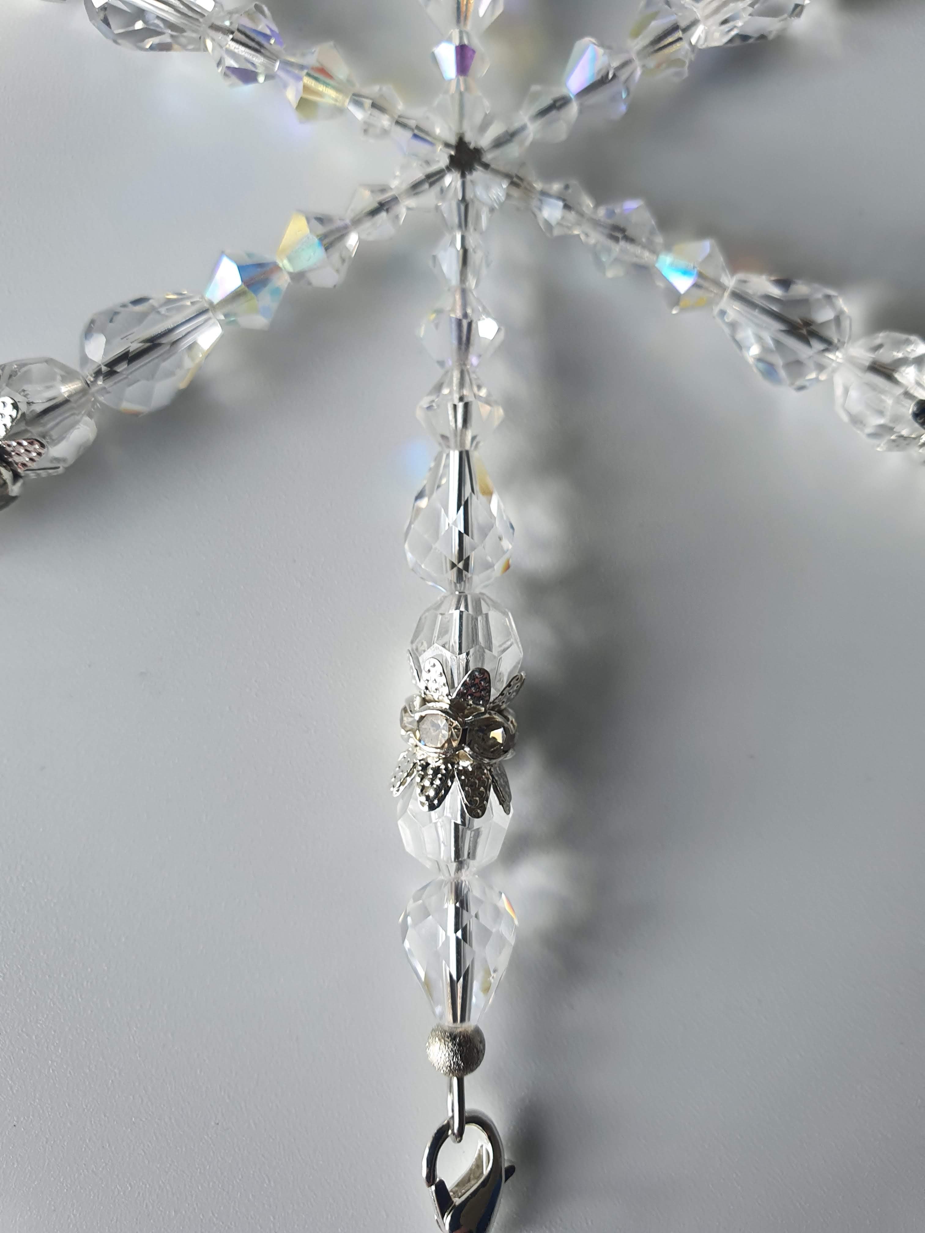 Close up of a silver star suncatcher with clear beads.