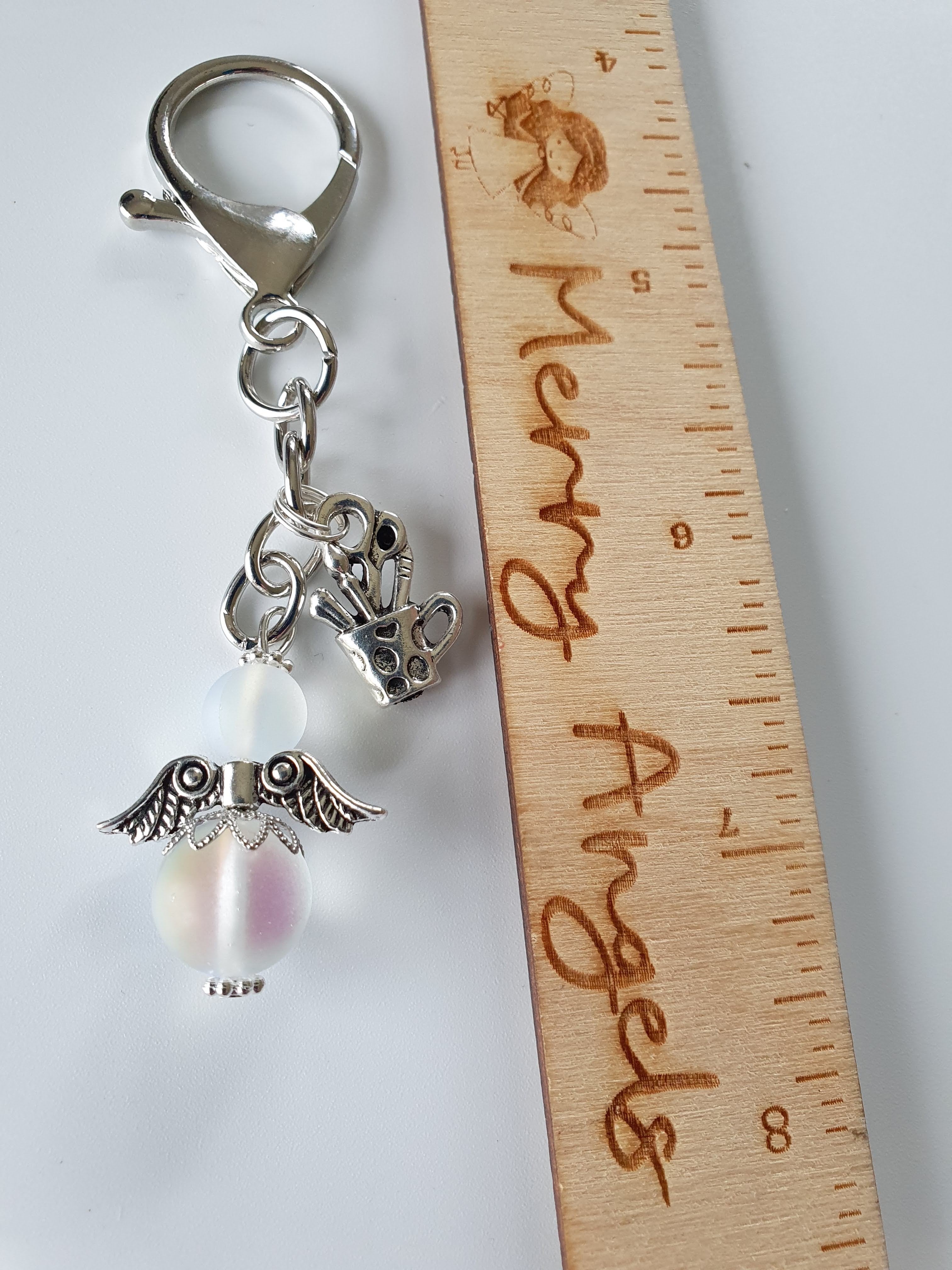This is a picture of a silver angel keyring with one charm.