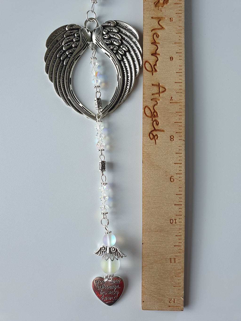 Silver angel wing hanging charm, with a silver heart charm and white angel with silver wings. 