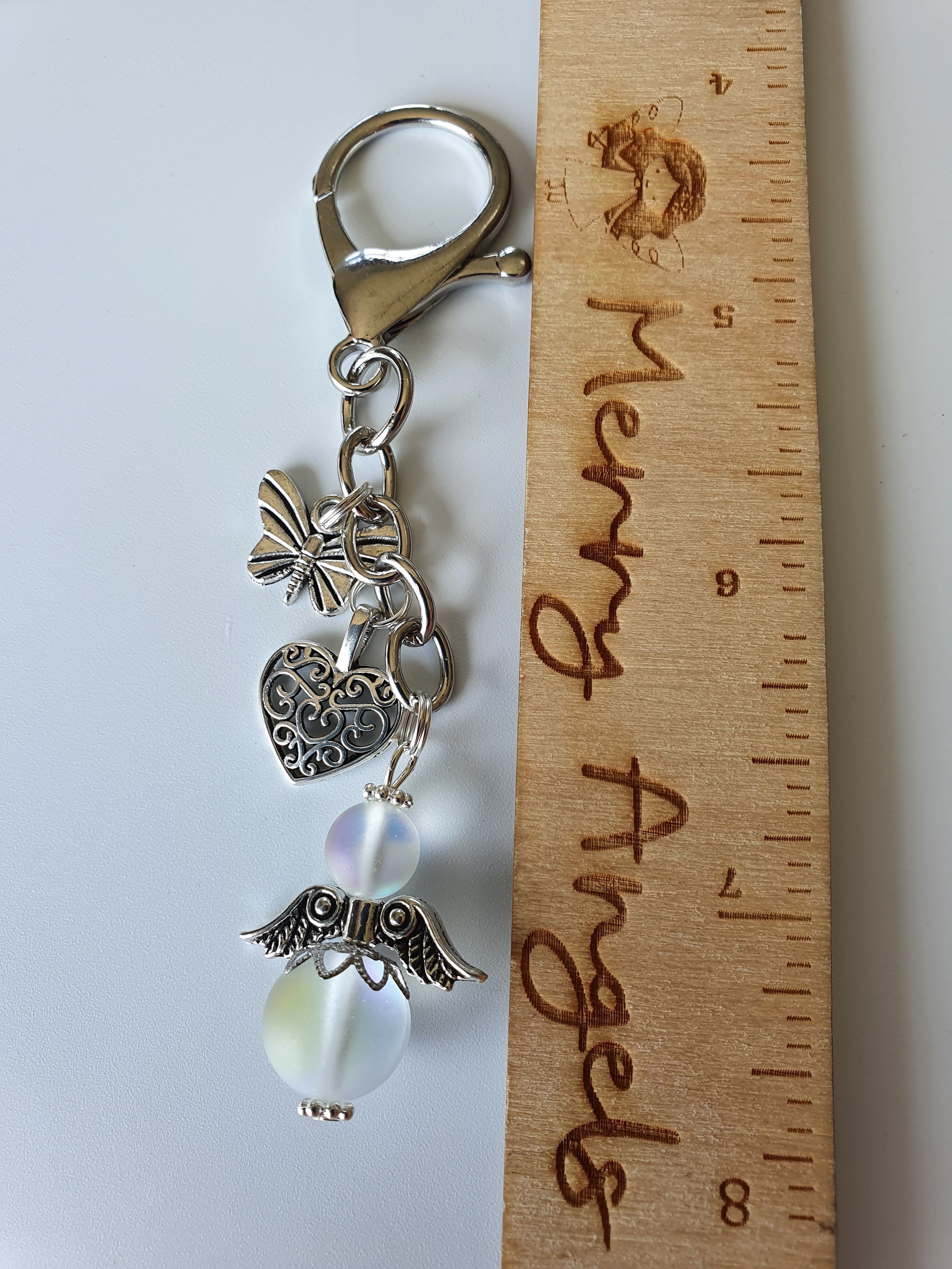 This is a picture of a silver angel keyring with two silver charms (heart and butterfuly)