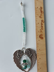 This is a picture of a silver angel wing hanging charm with a green angel in the centre and green beads