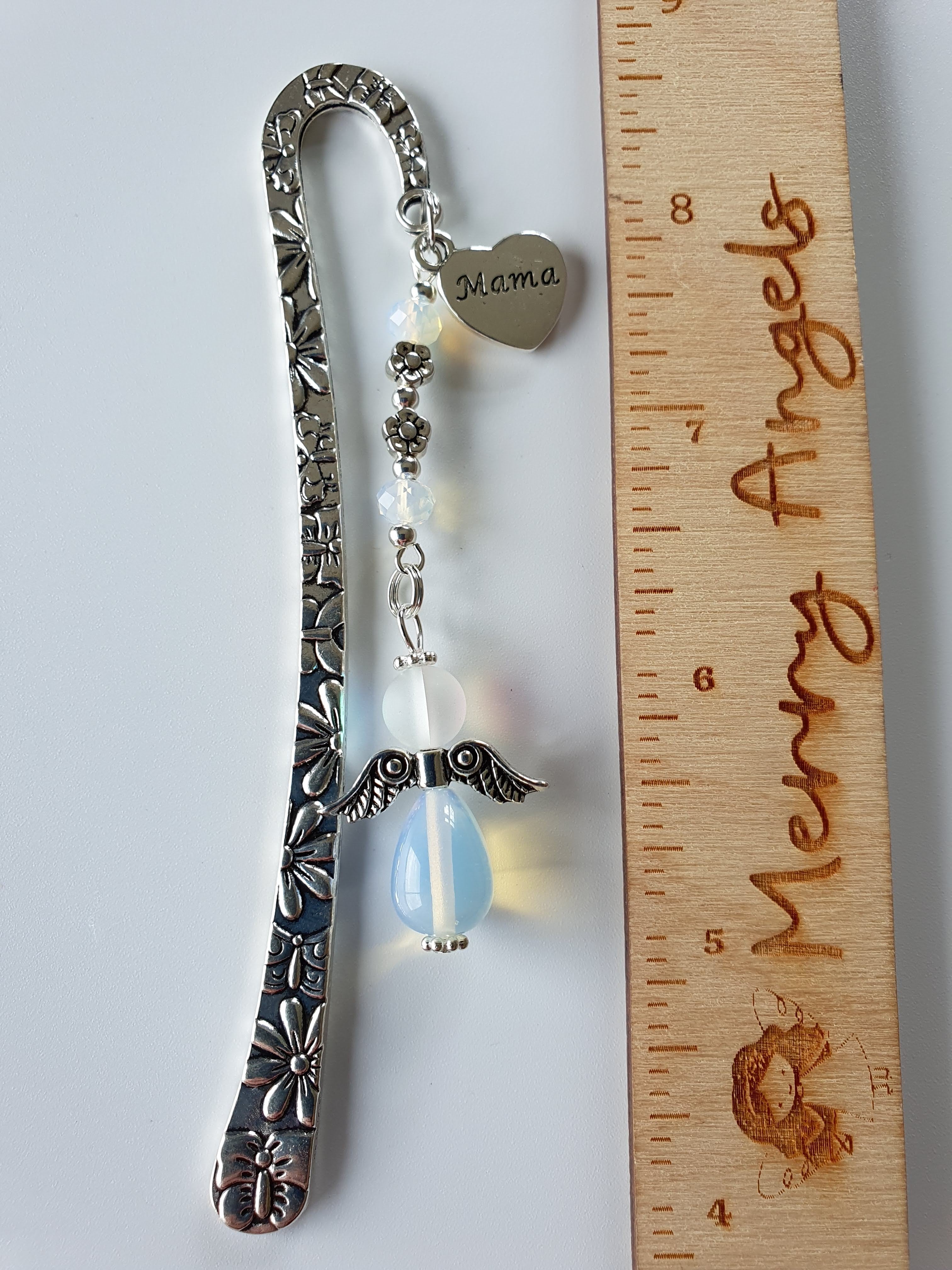This is a picture of a silver bookmark with a white and blue angel and 'mama' charm