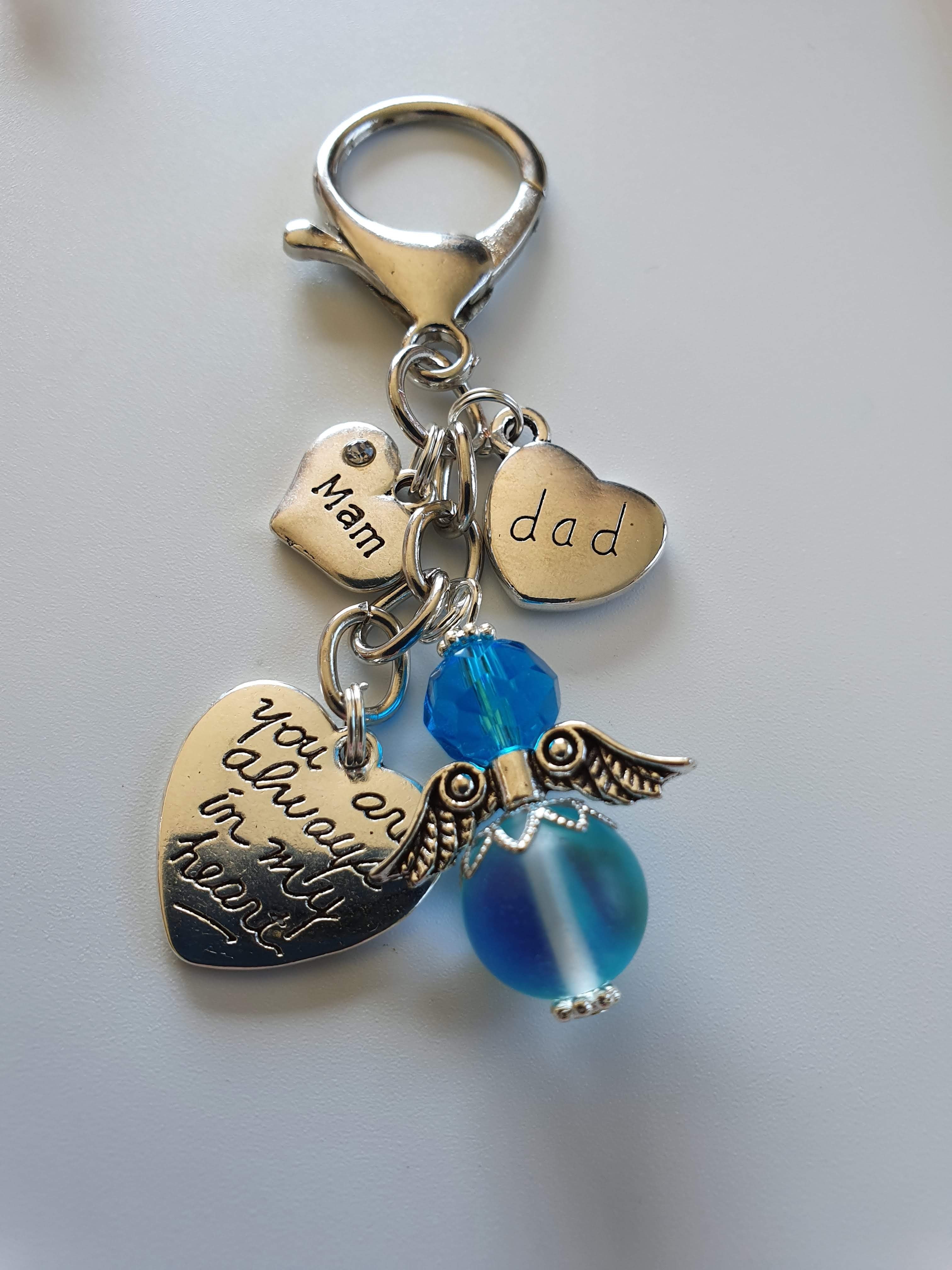 This is a picture of a silver angel keyring with beautiful silver charms. The angel is blue