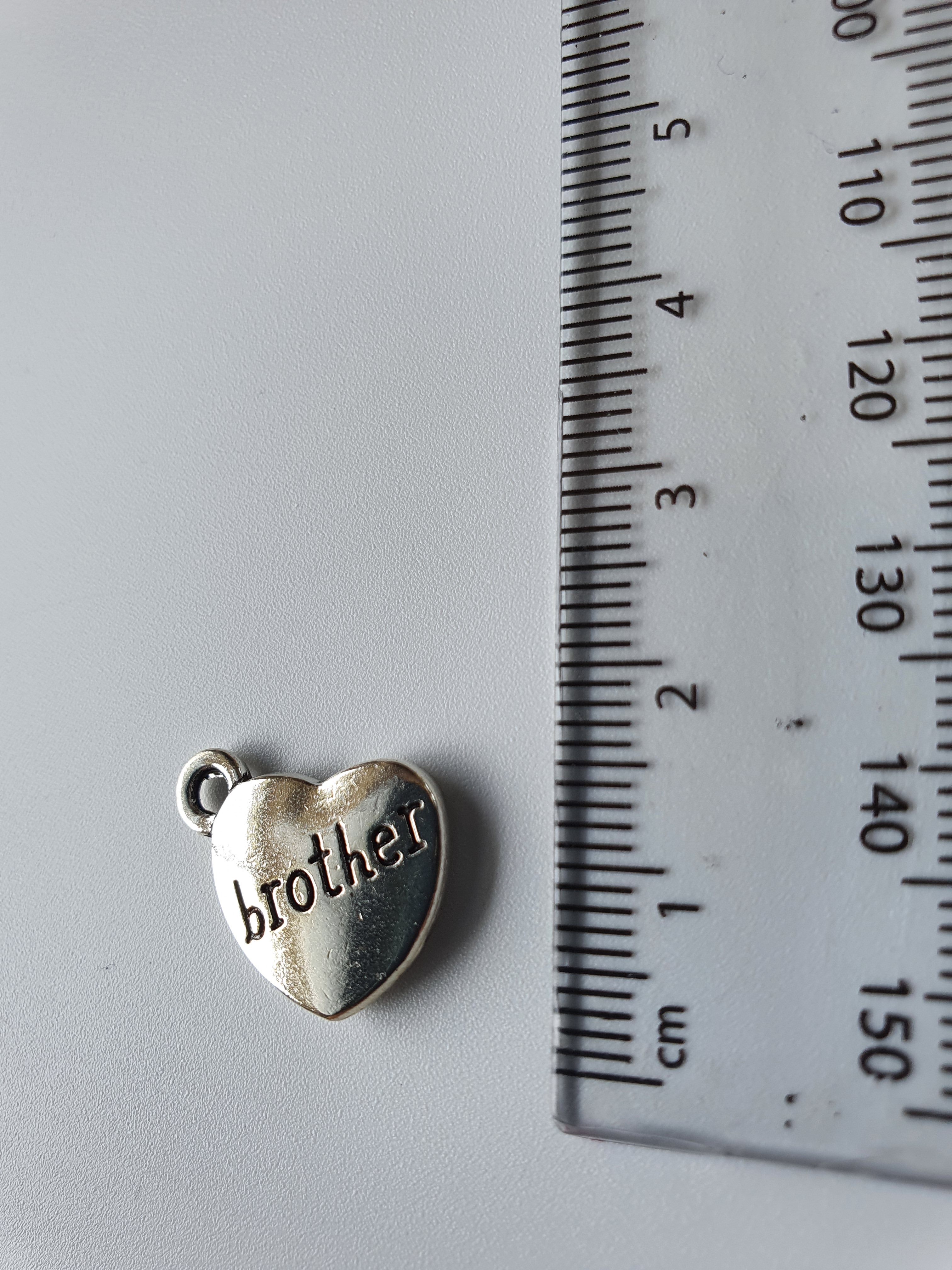 Silver charm with 'brother' engraved on it
