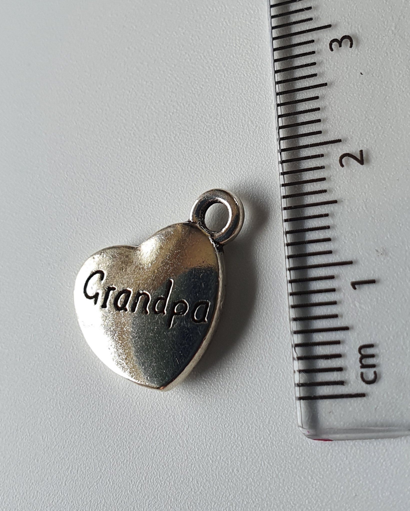 Silver charm with 'Grandpa' engraved on it