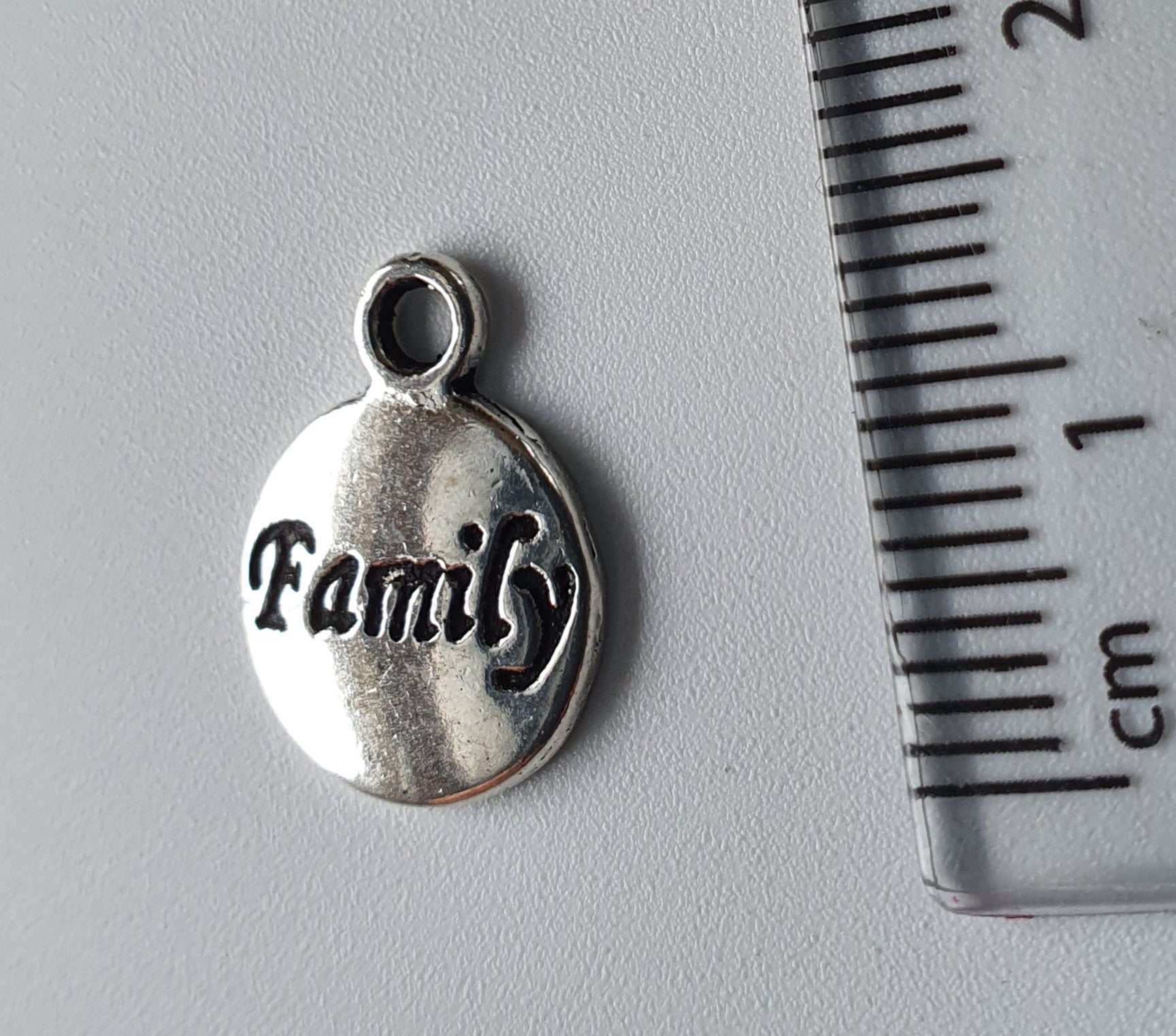 Silver charm with 'family' engraved on it