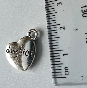 Silver charm with 'daughter' engraved on it