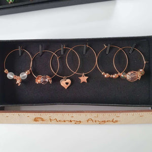 This is a picture of 6 rose gold wine glass charms