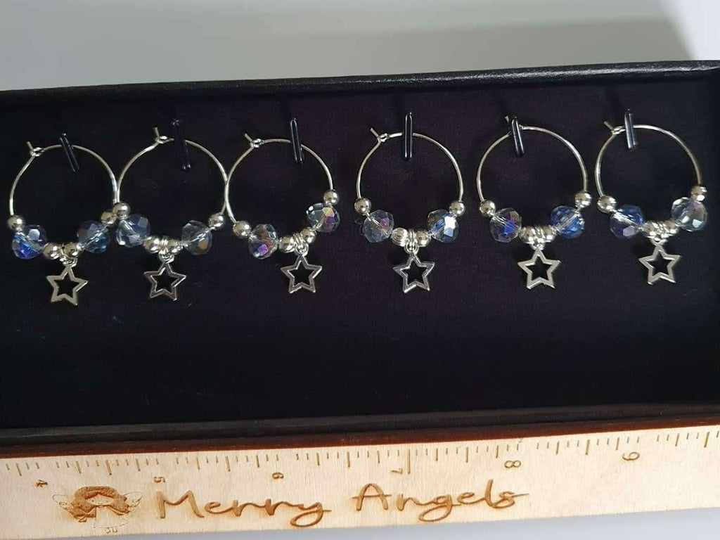 Set of 6 silver wine glass charms with mermaid coloured beads and star charms hanging from them. 