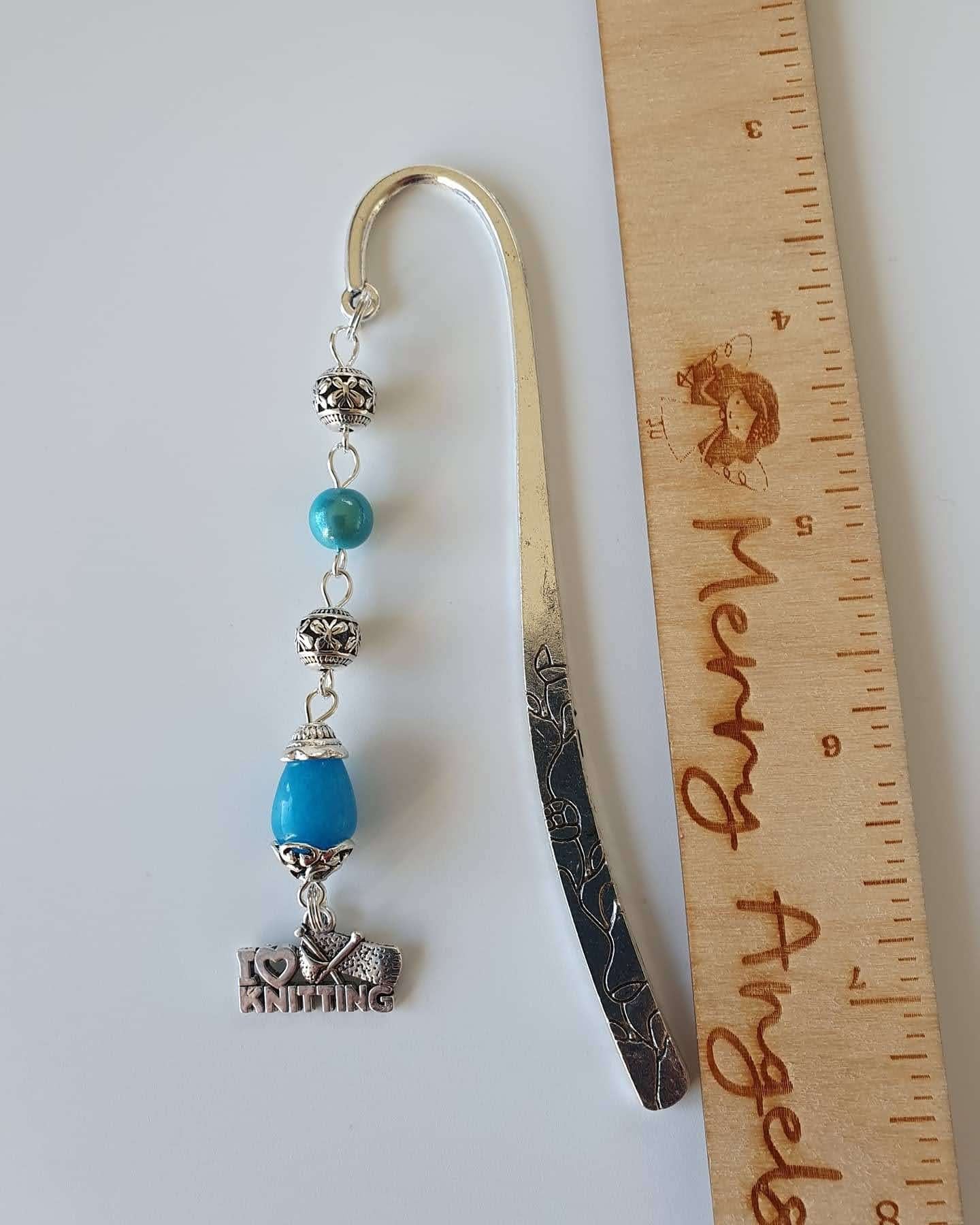 This is a picture of a silver bookmark with blue details and an 'I love knitting' charm on the end. 