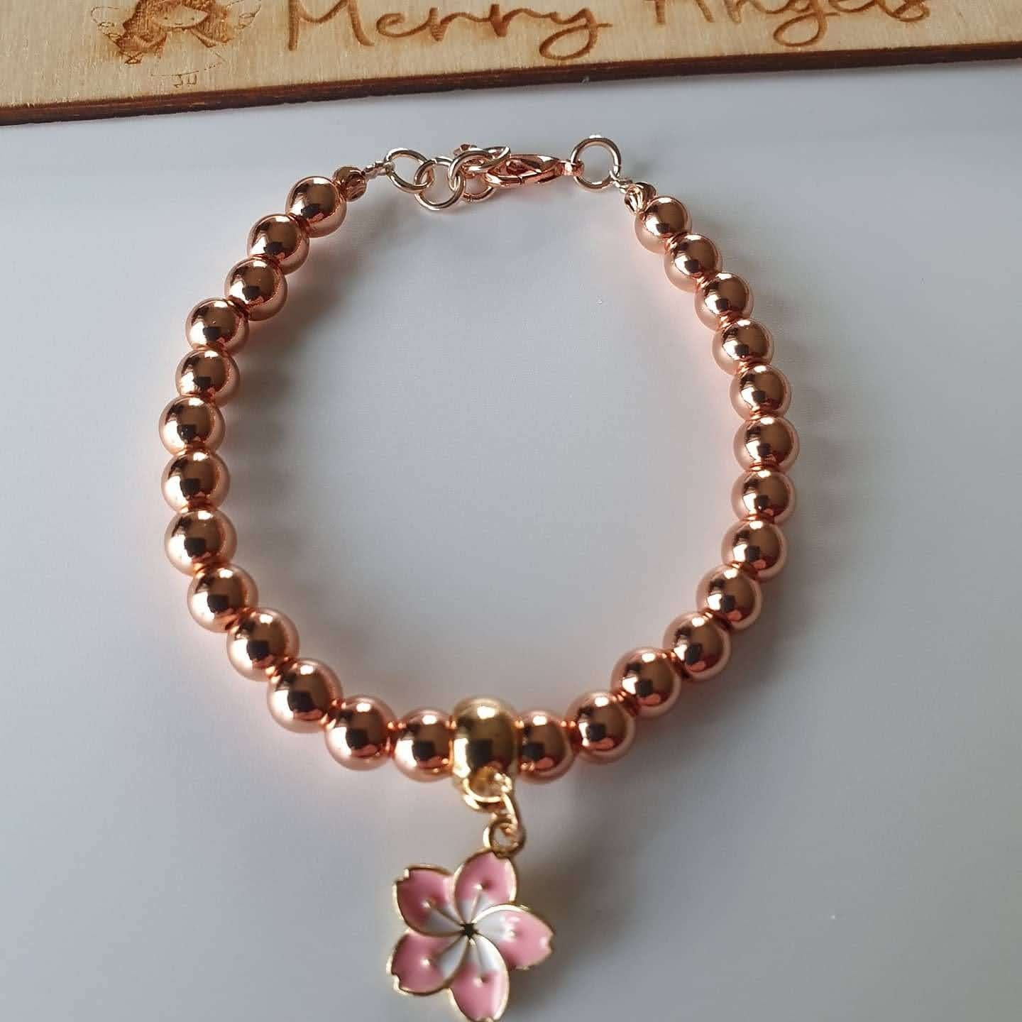 This is a picture of a rose gold bracelet with a  flower charm