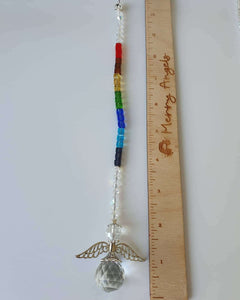 This is a picture of an angel rainbow 10.5 inch suncatcher laid out beside a ruler