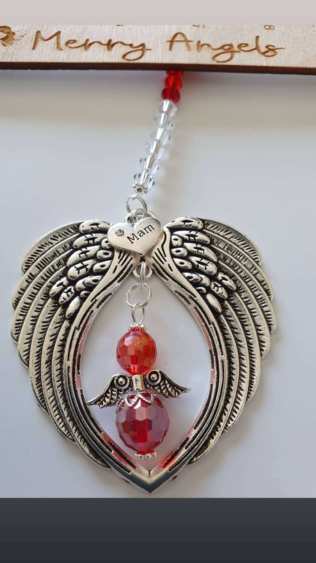 This is a picture of an angel wing hanging char, with a 'mam' charm and a red angel with silver wings