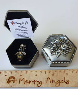 This picture shows an angel hug in a beautiful silver box with rose details on the lid and a poem about angels printed on a piece of card. 